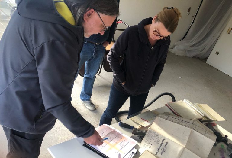 Herr Dipl.-Ing. Jörg Mackfeld schaut sich mit einer Kundin die Bestandspläne bei einem Ortstermin an.